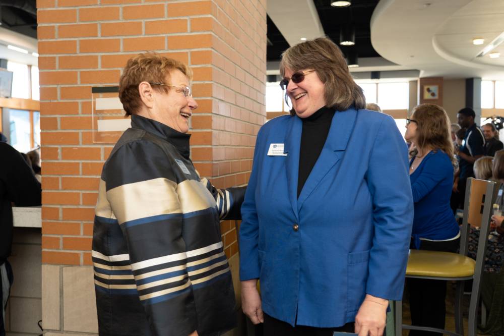 Lynn Blue laughing with a guest at the Lynn M. Blue Connection Naming Ceremony